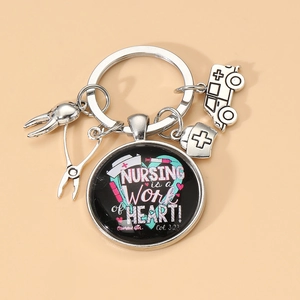 Détail du porte-clés infirmier argenté avec pendentif en verre cœur et breloques médicales