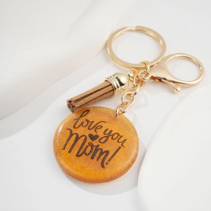 Détail d'un porte-clés doré avec pendentif pailleté et texte Love you Mom gravé