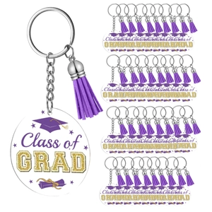 Macro view of 24pcs graduation acrylic keychains with purple tassels and Class of GRAD text