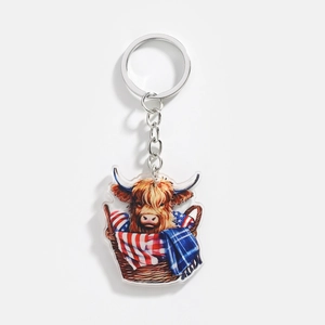 Close-up of acrylic Highland cow keychain with American flag scarf in a basket