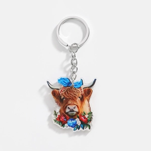 Detail of acrylic Highland cow keychain with floral accents and silver metal ring