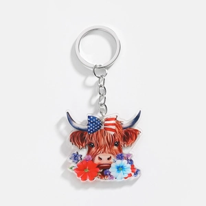 Detail of acrylic Highland cow keychain with American flag bow and floral decorations