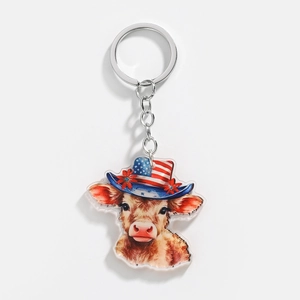 Detail of acrylic Highland cow keychain with Independence Day hat and floral accents