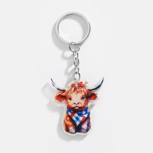 Detailed view of acrylic Highland Cow keychain with festive scarf and metal ring clasp