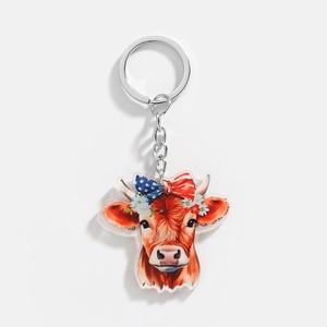 Detailed view of acrylic Highland cow keychain with American flag bow and floral wreath