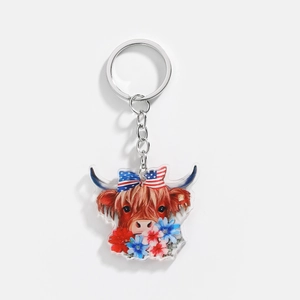 Detailed close-up of acrylic highland cow keychain with American flag bow and floral motifs