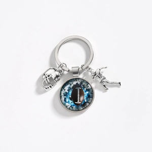 Detailed view of silver football helmet, player and glass dome charms on the keychain