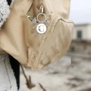 Porte-clés dentaire créatif avec lettre G rose attaché à un sac en toile beige