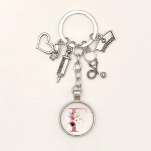 Detail of medical keychain showing syringe, stethoscope, heart and floral letter charms