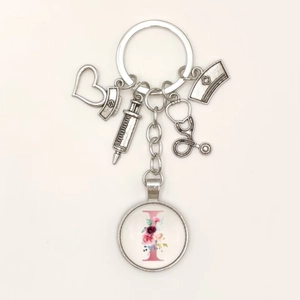 Detailed silver medical keychain with nurse charms, stethoscope, and pink floral letter I