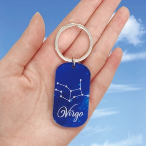 Détail d'un porte-clés Vierge en acrylique bleu foncé avec impression de constellations
