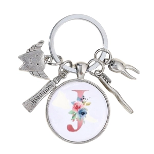 Détail du porte-clés dentiste avec breloques dentaires et pendentif lettre J fleurie