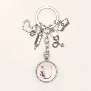 Detail of medical theme keychain with syringe charms and a floral letter U pendant