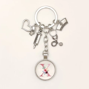Detailed nurse keychain with stethoscope, syringe, and floral letter X charm on white background