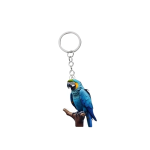 Detailed view of acrylic parrot keychain with blue and gold macaw design on white backdrop