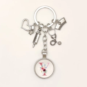 Detail view of medical keychain with syringe, heart charms and letter Y pendant