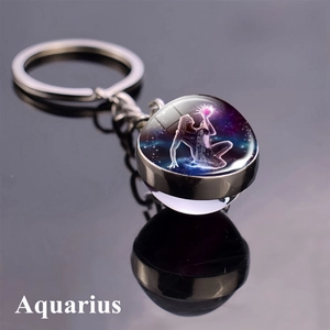 Macro shot of Aquarius constellation double-sided glass ball keychain with silver metal ring