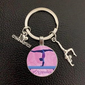 Close-up of silver metal gymnastics keychain with I love gymnastics charms on leather