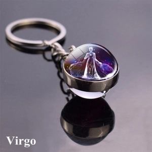 Macro shot of Virgo zodiac glass ball keychain with starry constellation on black surface