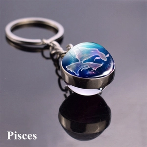 Macro view of double-sided glass sphere keychain with Pisces constellation and silver ring