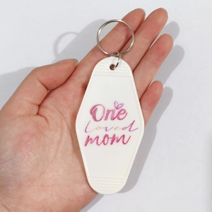 White diamond shaped motel keychain with pink One loved mom text and heart design