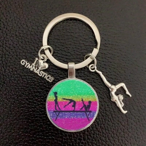 Detail of metal gymnastics keychain with rainbow glitter and I Love Gymnastics charms