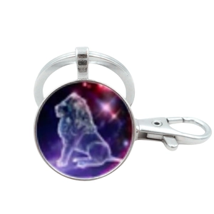 Polished silver metal keychain with round Leo constellation glass gem pendant on white background
