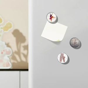 Macro view of 3 ballet magnets featuring dancers and shoes on a metallic surface