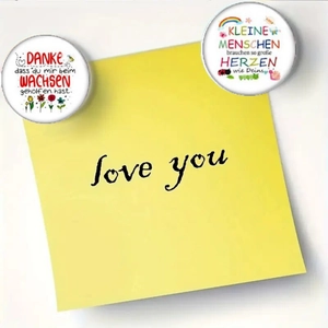 Detailed view of round fridge magnets featuring German thank-you quotes and floral designs