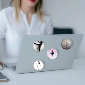 Close-up of glass ballet dancer magnets applied to a laptop cover for decoration