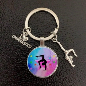 Detailed view of silver gymnastics keychain with I love gymnastics heart charm and charms