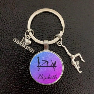 Close-up of silver gymnastics keychain with custom Elizabeth name and heart pendant