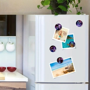 Detail showing glass zodiac fridge magnets on a white refrigerator door