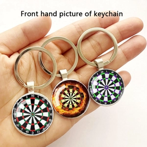 Macro detail of three dartboard keychains with metal rings and creative glass pendants