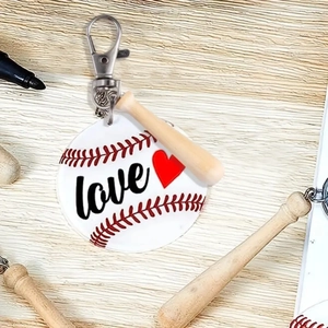 Detailed shot of a baseball keychain with a wooden bat and acrylic love heart tag