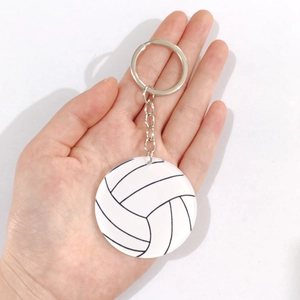 Dettaglio del portachiavi da pallavolo tenuto in mano con anello in metallo argento