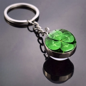 Detailed macro view of silver metal keychain with double-sided glass ball clover pendant
