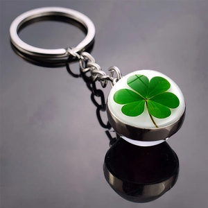 Detailed macro shot of a real four-leaf clover preserved in a double-sided glass ball keychain