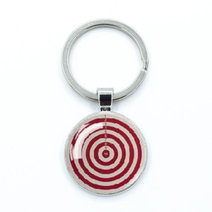 Close-up of a silver alloy dartboard keychain with red and white target design