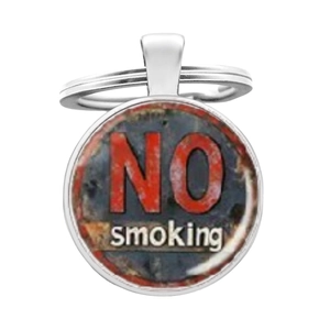 Macro shot of silver metal key ring with a vintage rusty No Smoking warning pendant logo