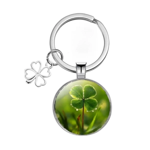 Close-up of silver keychain with lucky green four leaf clover glass cabochon pendant