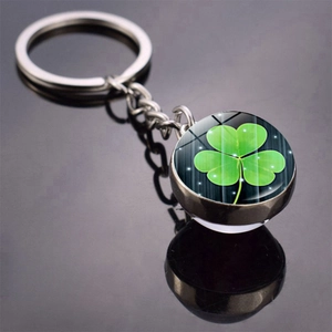 Macro shot of glass ball keychain featuring a four-leaf clover charm with reflection
