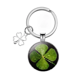 Detailed view of silver clover keychain featuring a green glass gem pendant and metal leaf charm