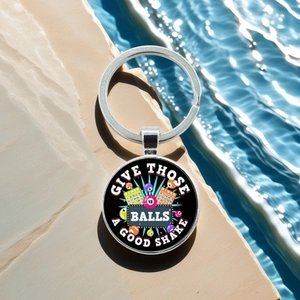 Macro detail of silver bingo ball keychain featuring printed fun quote on stone background