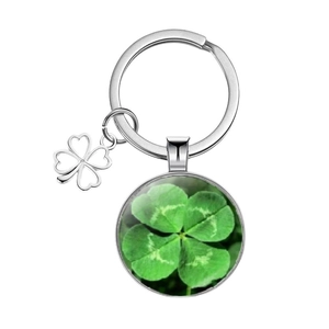 Silver four-leaf clover keychain with glass cabochon pendant on white background