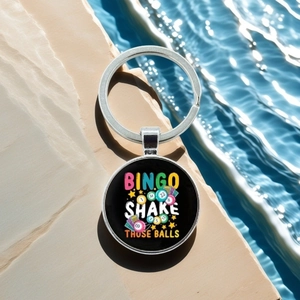 Detail of metal Bingo keychain featuring colorful numbered balls against a pool water backdrop
