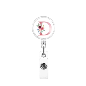 Detail view of retractable silver badge reel with floral letter D on white background