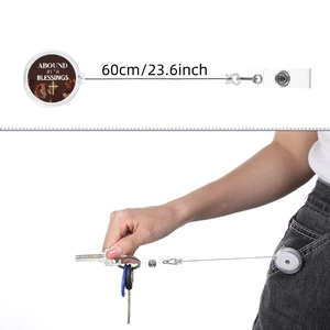 Retractable badge reel with cross design and 60cm cord shown in use on jeans