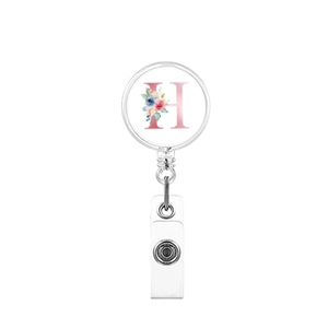 Macro detail of retractable badge holder with floral letter H on white background