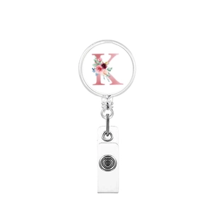 Detail of retractable badge holder with floral letter K design on white background